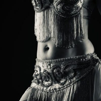 Body part of Belly dancer over black background